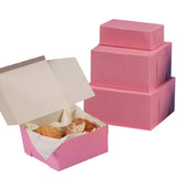 Pink cake and bakery boxes shown on a white background, with one open box containing pastries and a stack of three closed boxes behind it.